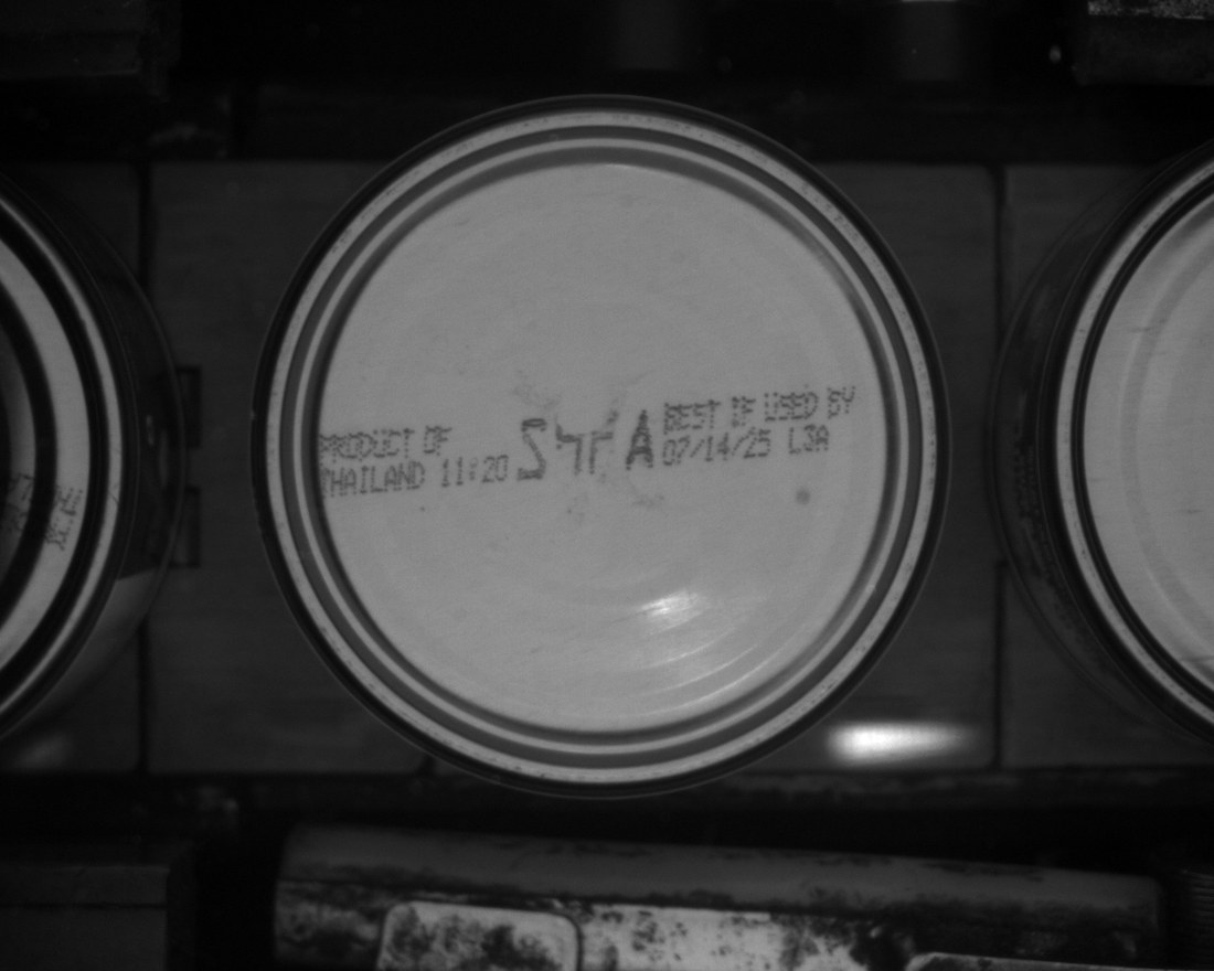 Machine vision frame of a can bottom with the four-character product code inked across the dome