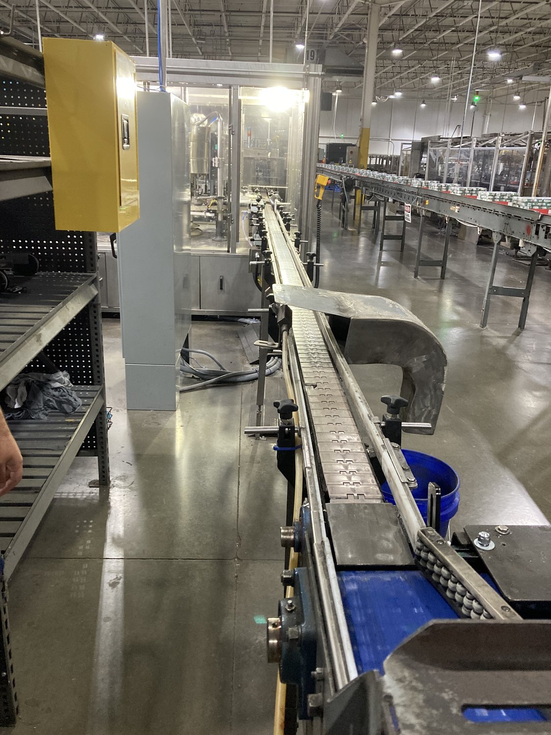 Cans travelling single file along the packaging conveyor at the cannery