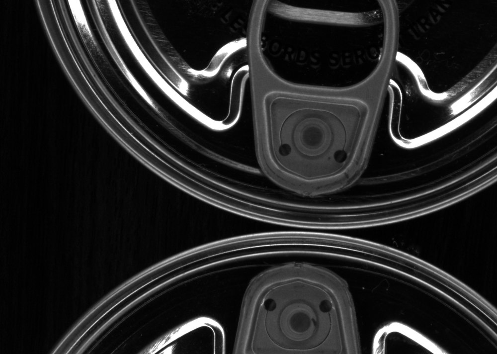 Machine-vision view of a can easy-open end with the opening rivet checked for position