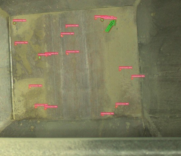 Camera view inside a probox showing detected contamination including a green object
